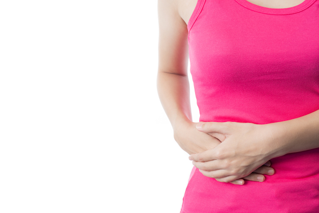 Woman holding stomach from cramping.