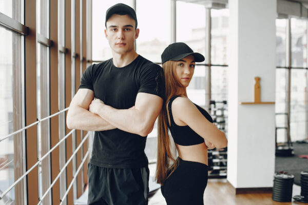 man and woman standing at gym.