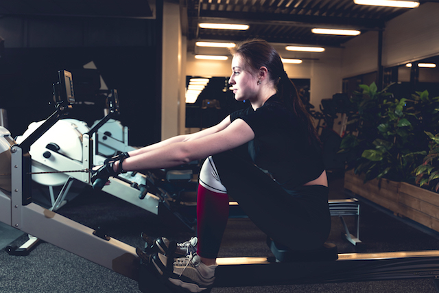 Girl on rowing machine at gym.