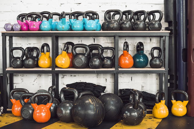 many kettlebells organized in a gym.