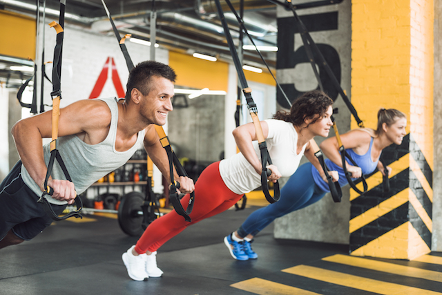 three people in a fitness TRX class, great for cross-training.