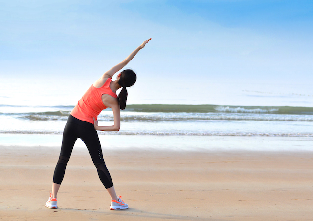 woman stretching on the beach.