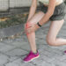 a runner holding her knee in radiating pain.