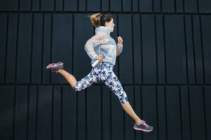woman running in front of a black background.