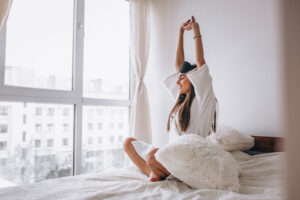 woman stretching as she just woke up.