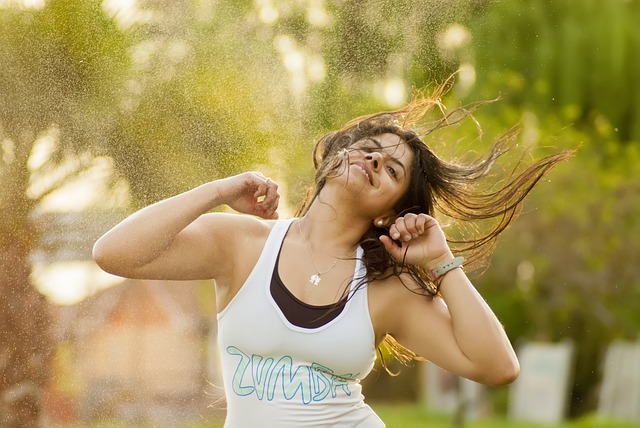 woman using her arms to dance while wearing a zumba shirt. 