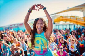woman making a heart with her hands while dancing zumba.